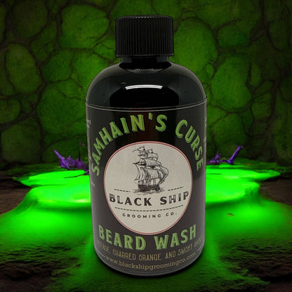 Bottle of Samhain's Curse Black Ship Beard Wash with a green and black ship logo on a textured green background.